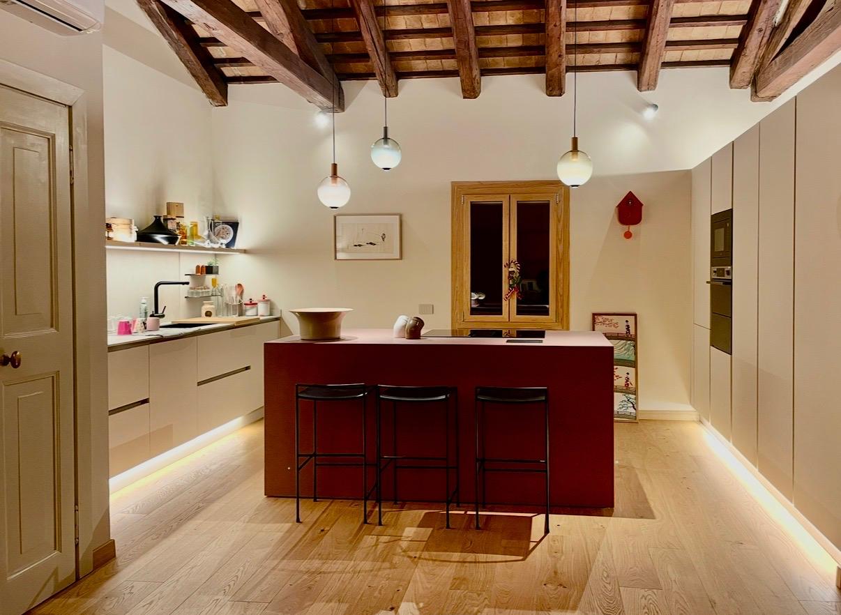 Cucina con isola e travi a vista in un immobile ristrutturato a Treviso