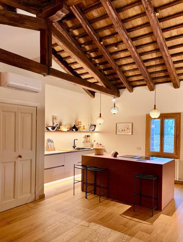 Cucina essenziale con mensolone a vista e travi restaurate