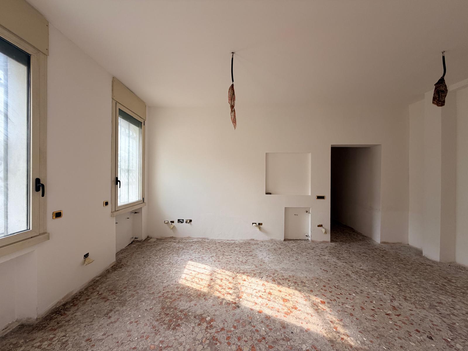 Soggiorno allo stato originale, con pavimento in graniglia